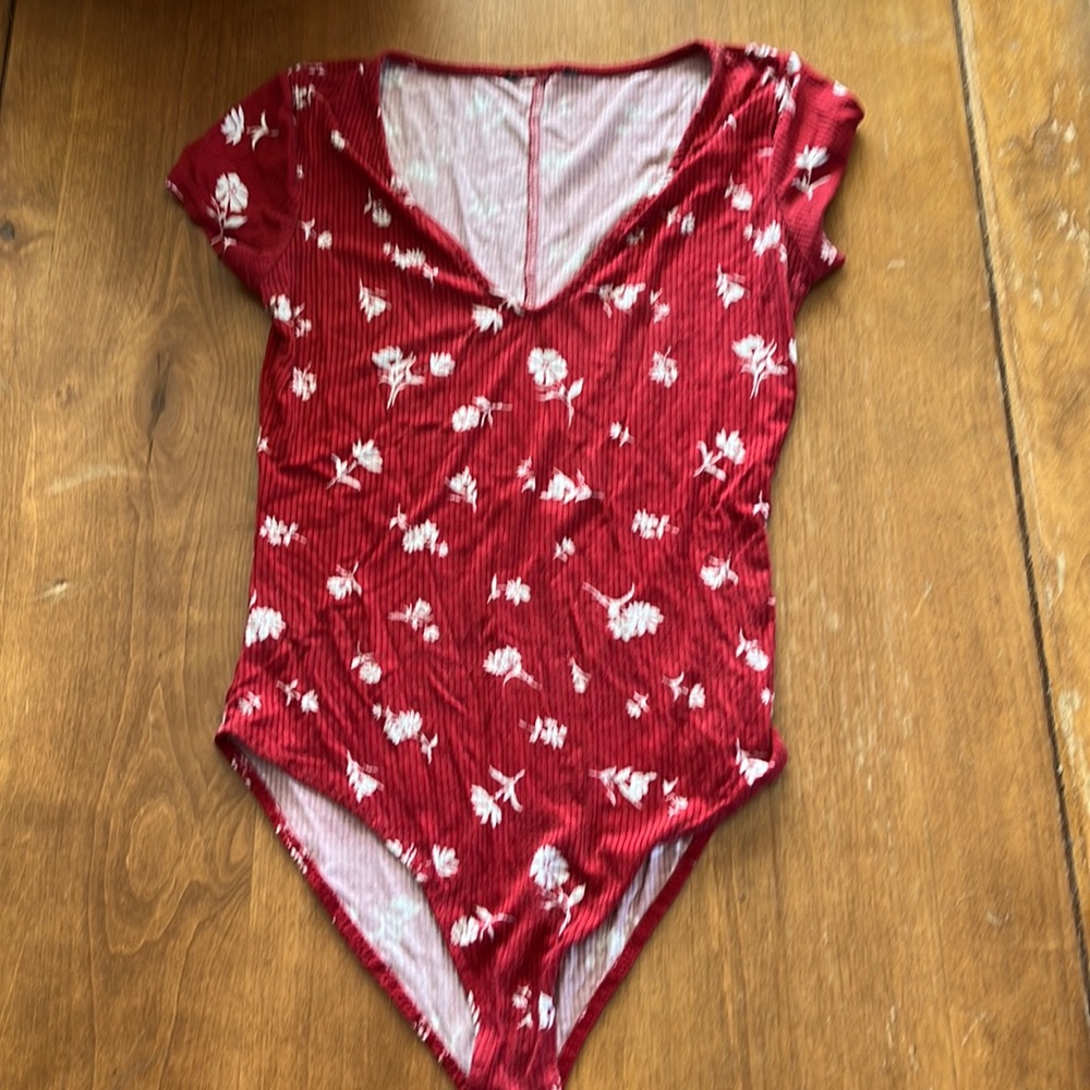 Red bodysuit with white floral details.